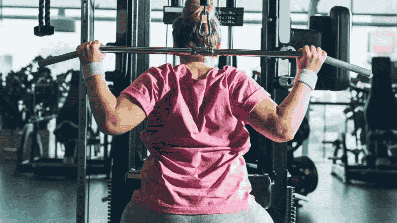 Mulher praticando musculação, como parte do tratamento do lipedema.