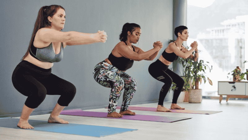 Mulheres realizando agachamento sem carga, atividade física segura para tratamento do lipedema.